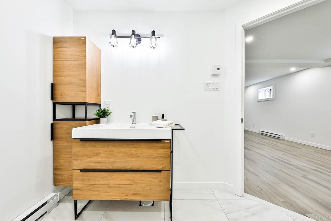 Une salle de bain avec une vanité en bois et un lavabo.