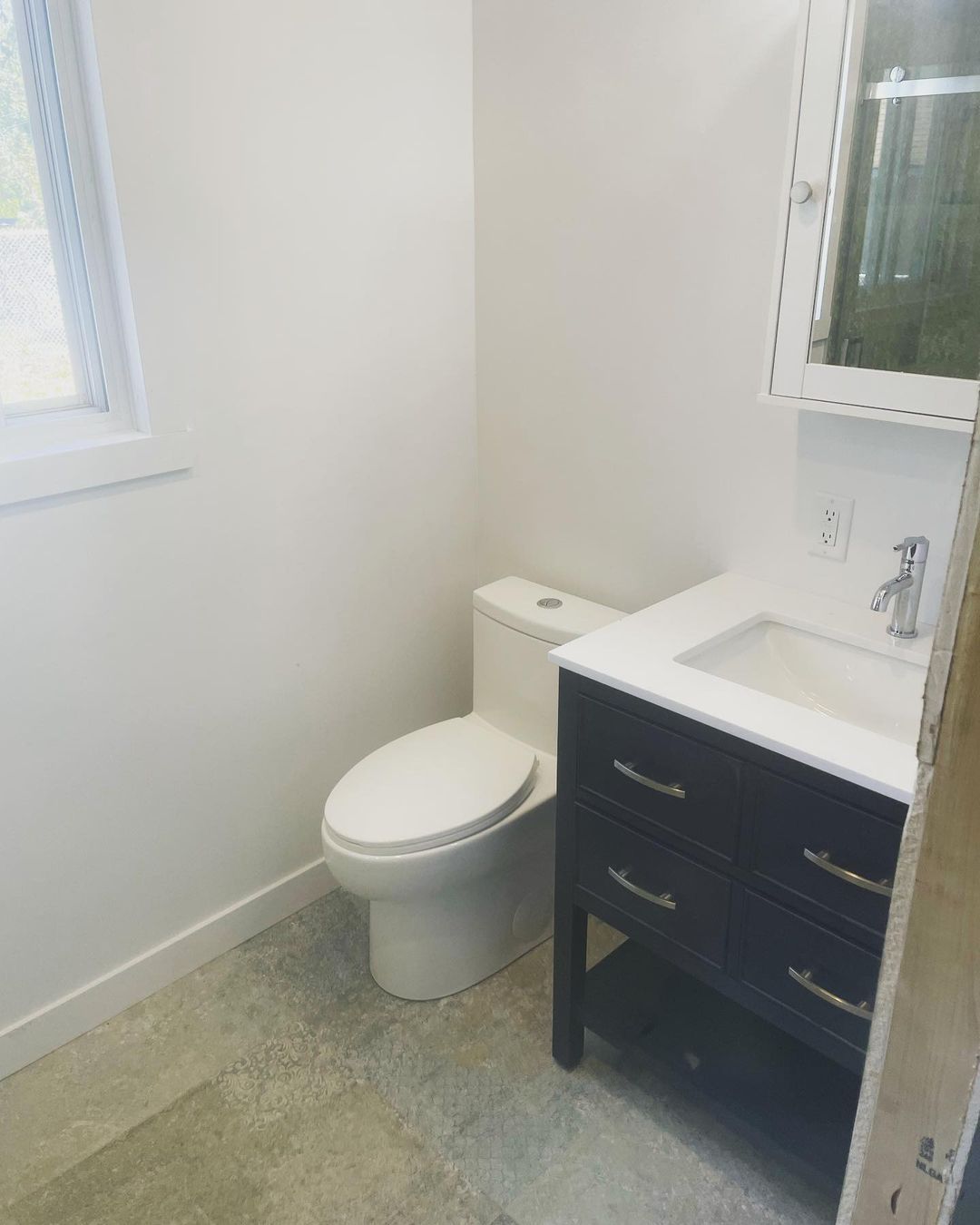 Une salle de bain avec WC, lavabo et miroir.