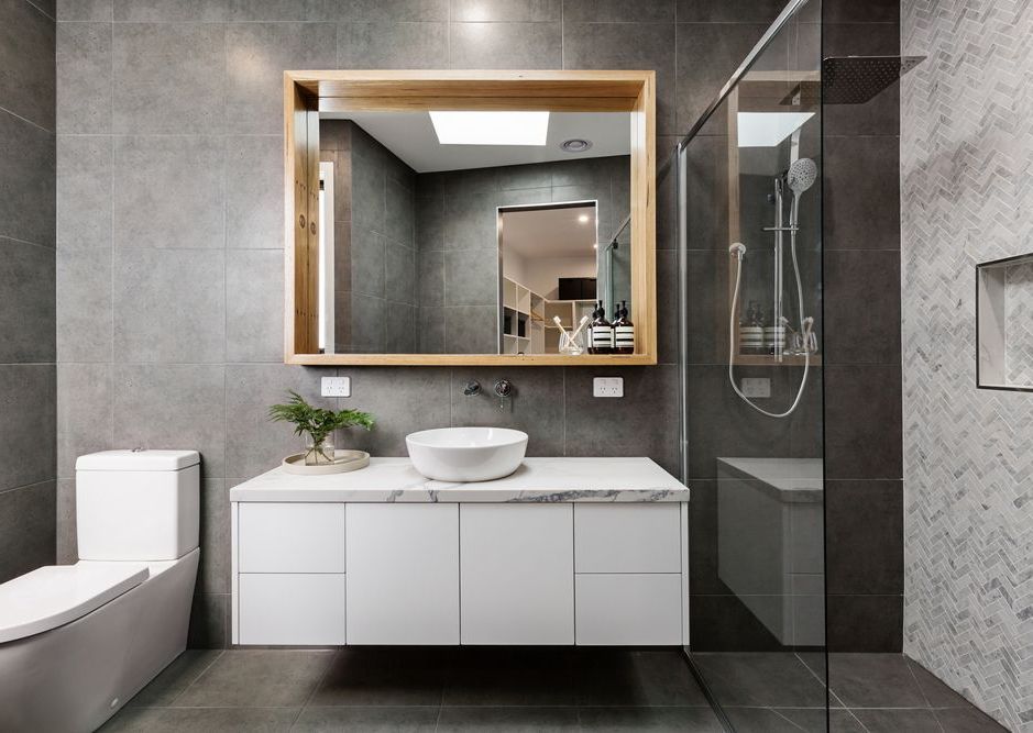 Une salle de bain avec lavabo, WC, douche et miroir.