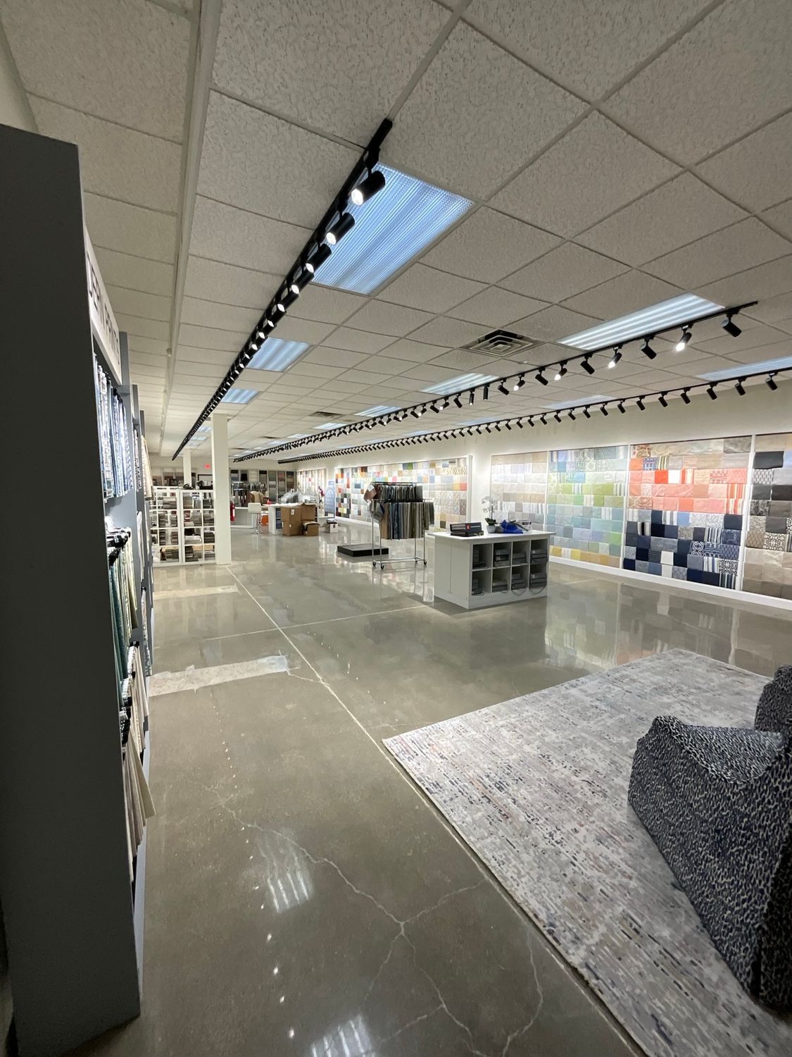 A large room with a lot of furniture and a rug in a store.
