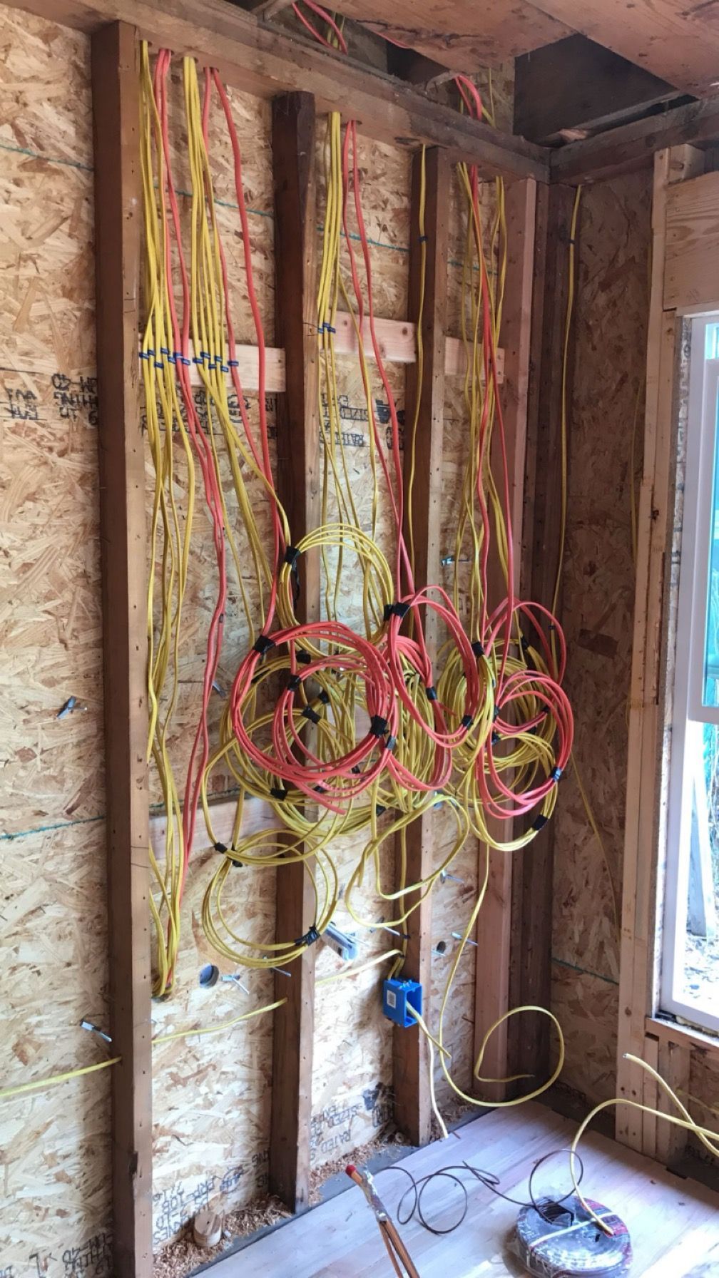 A bunch of wires are hanging from a wall in a room.