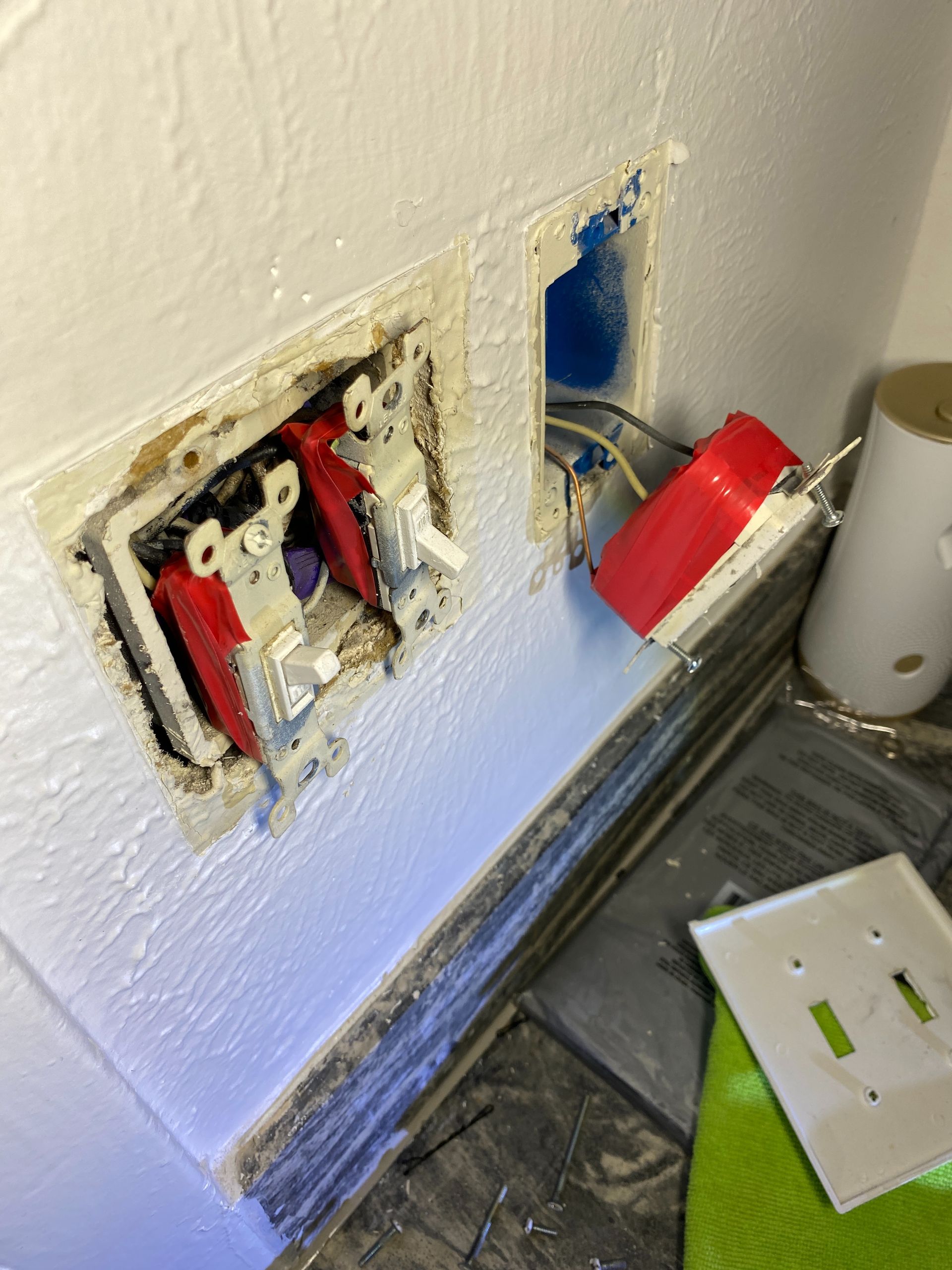 A light switch is being removed from a wall.
