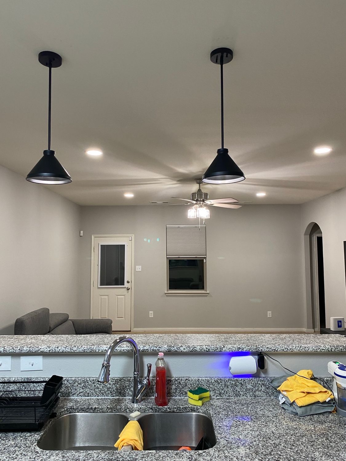 A kitchen with a sink and a ceiling fan.