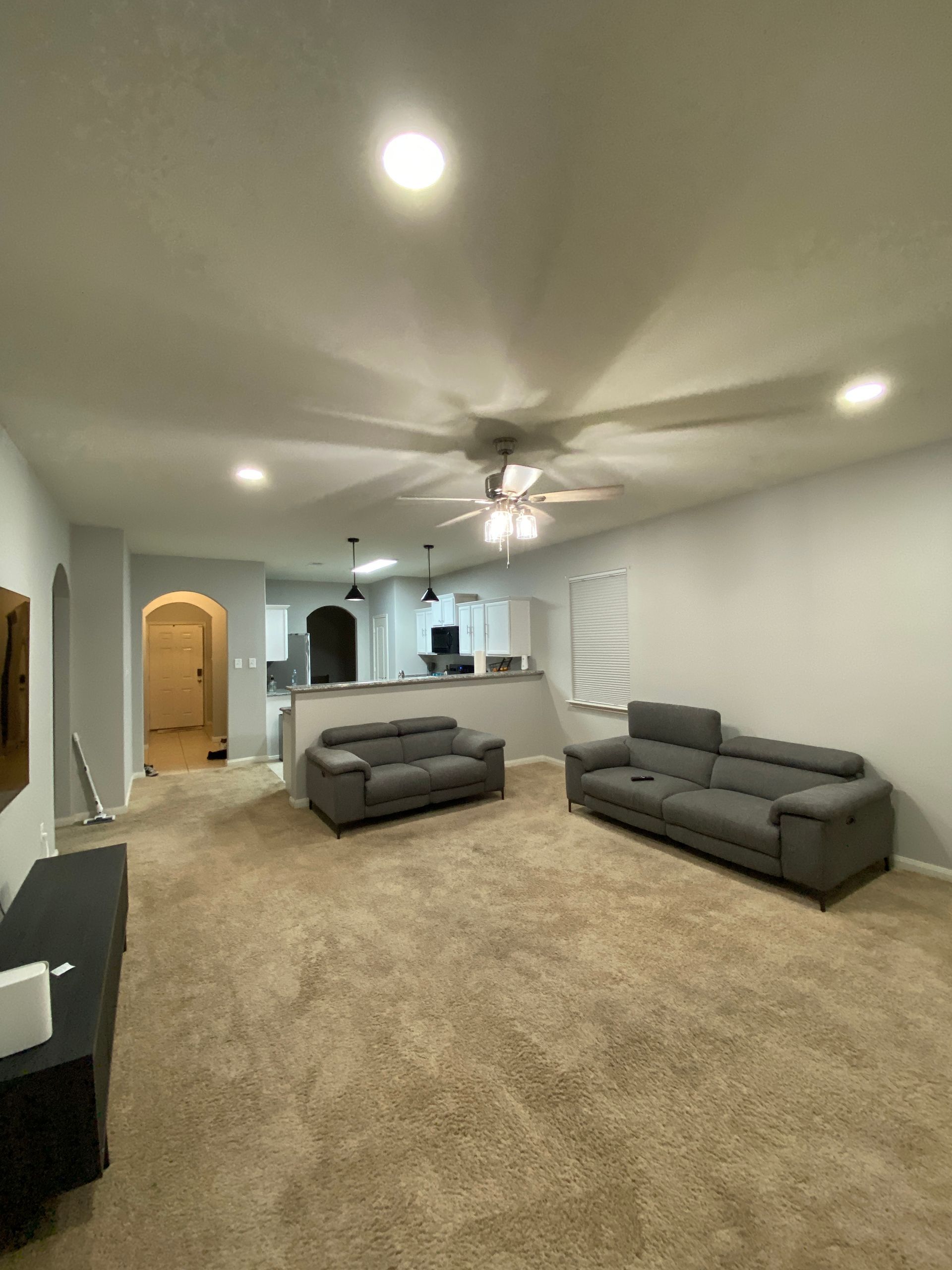 A living room with two couches and a ceiling fan.