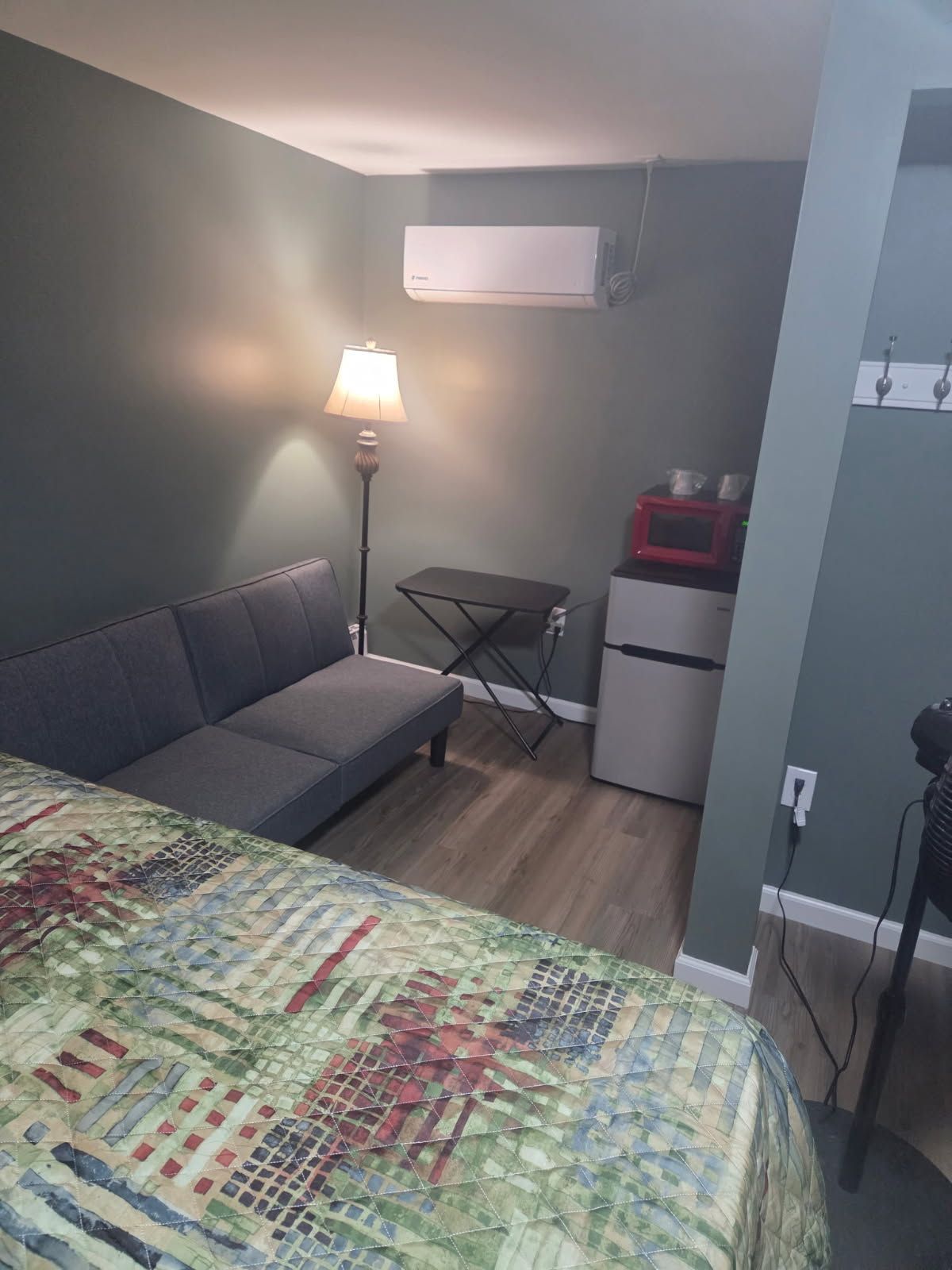 RV parked near a tan restroom building with a red door, trees in the background.