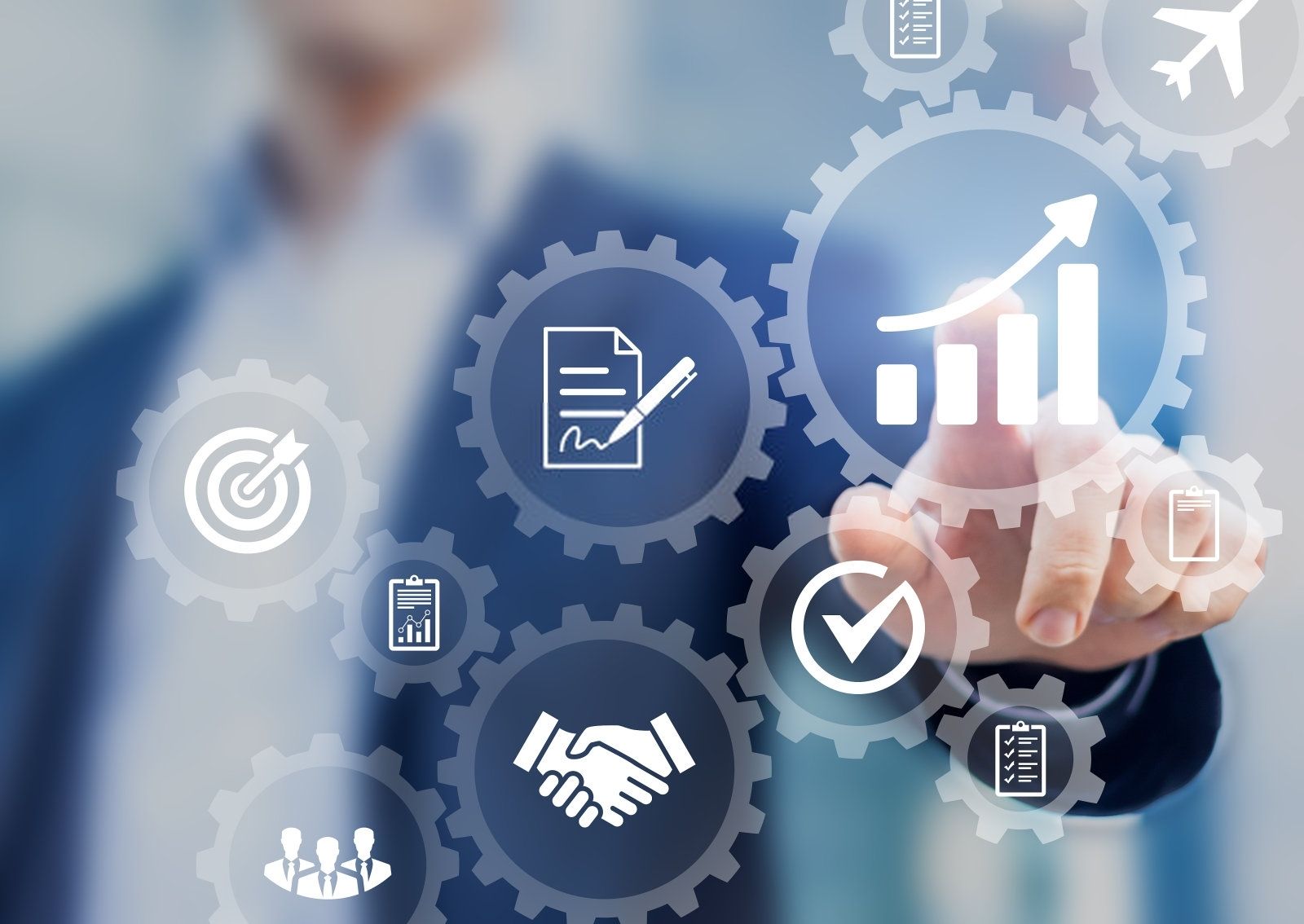 Een groep van negen personen in zakelijke kleding viert feest met opgeheven armen.