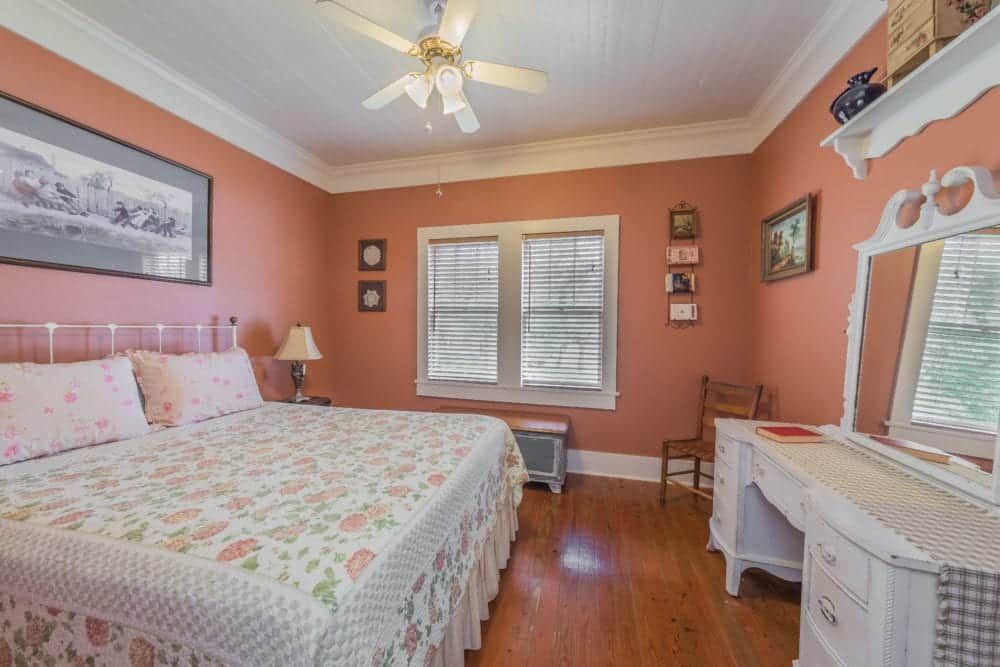 A bedroom with a king size bed and a ceiling fan