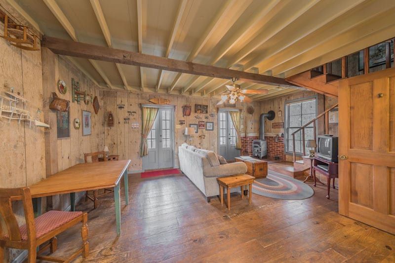 A living room with a couch , table , chairs and a television.