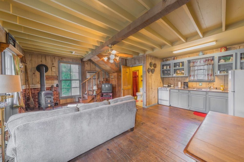 A living room with a couch and a kitchen in a house.