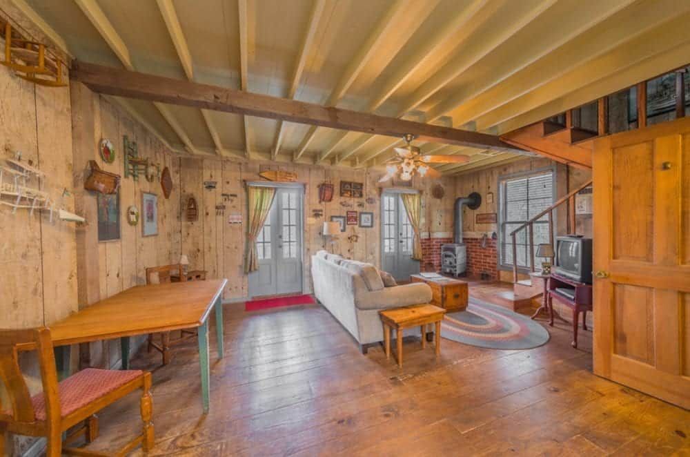A living room with a couch , table , chairs and a television.