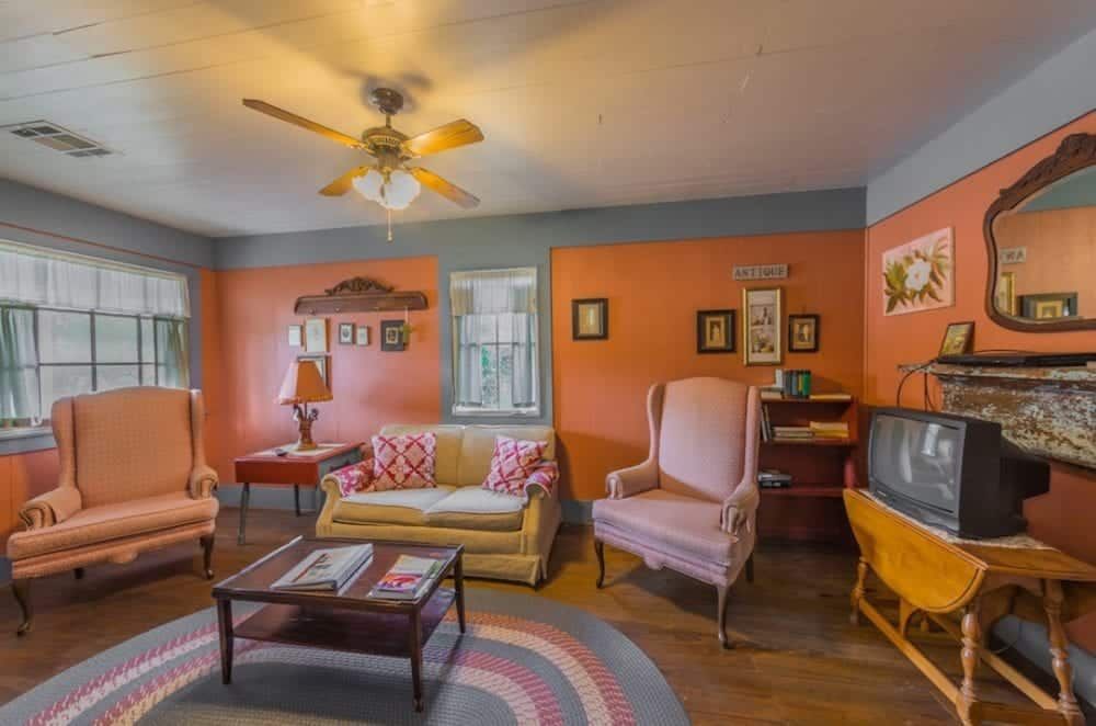 A living room with a couch , chairs , a coffee table and a television.