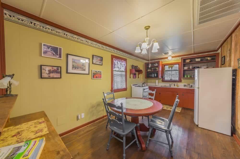 A kitchen with a table and chairs and a refrigerator.