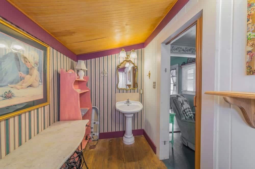 A bathroom with a sink and a painting on the wall.