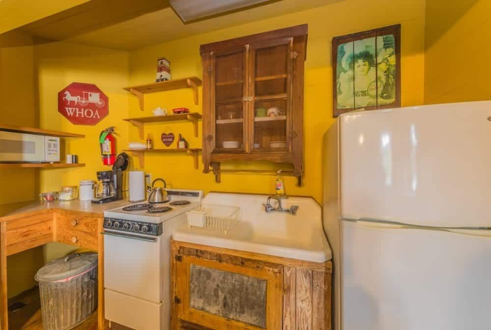 A kitchen with a stove , sink , refrigerator and microwave.