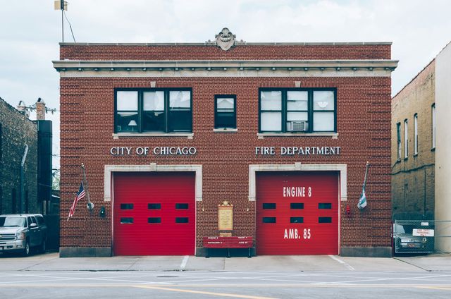 A red brick fire station with two red garage doors