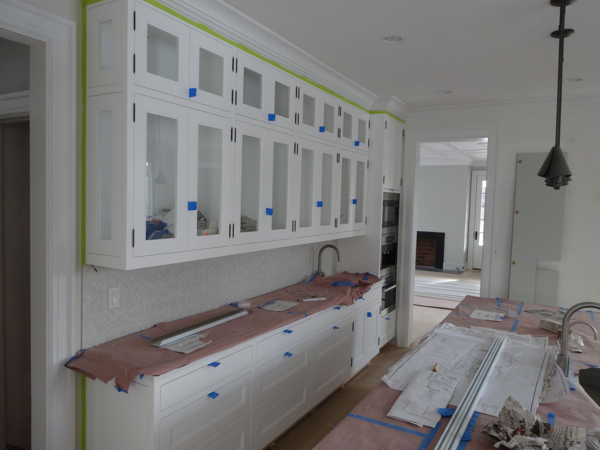 Interior of a home under construction, showing drywall on walls and ceiling, with open doorways and a window.
