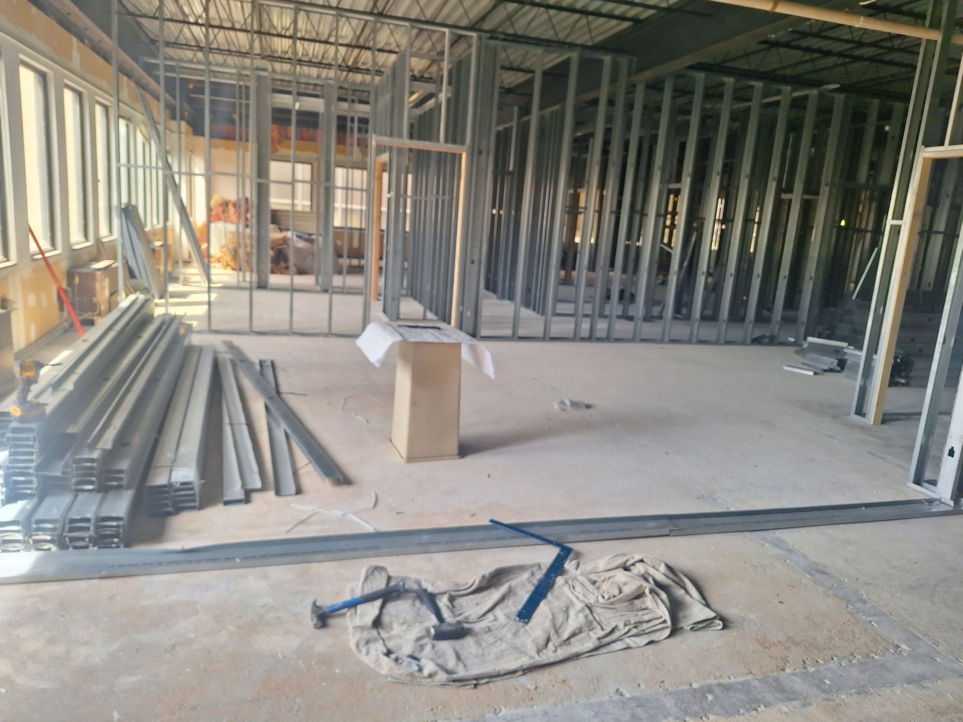 A person in green gloves lays cement blocks with mortar.