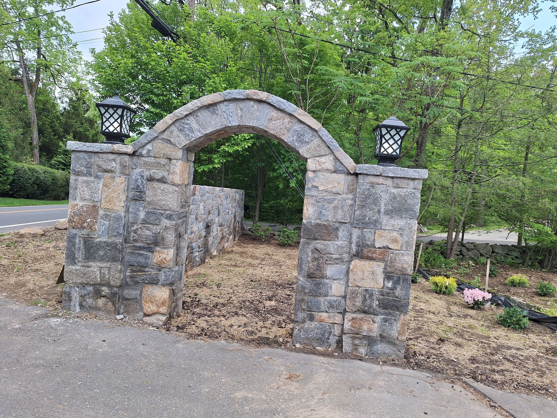 Bricklayer applying mortar to bricks with a trowel, building a red brick wall.