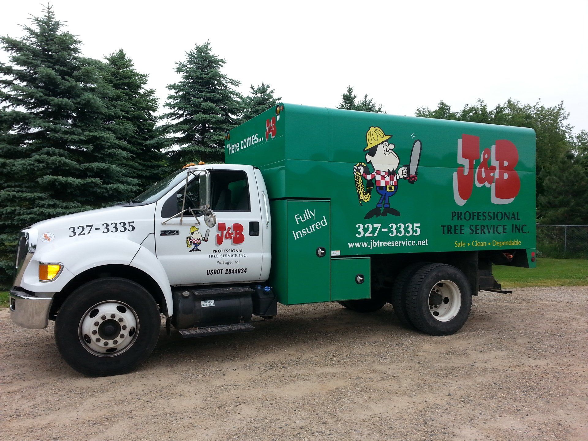 White and green J&B Professional Tree Service truck parked on gravel. A cartoon man holding tools is on the side.