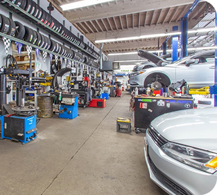 A car is parked in the middle of a garage. | TNT Tire Point S Auto Service