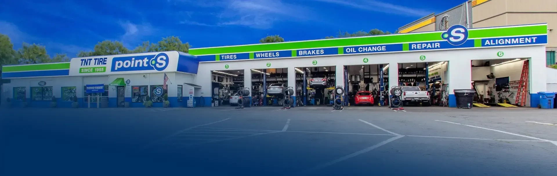A picture of a tire shop with a lot of cars parked in front of it. | TNT Tire Point S Auto Service