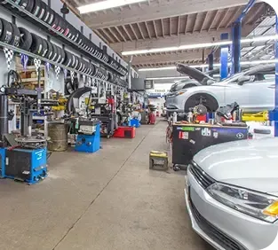 A car is parked in the middle of a garage. | TNT Tire Point S Auto Service