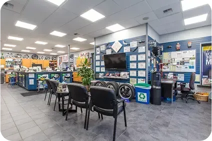 A large room with a lot of chairs and a tv on the wall | TNT Tire Point S Auto Service