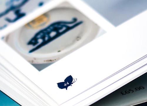 the caughley society blue and white pattern book is open to a page with a detail picture of the butterfly page number