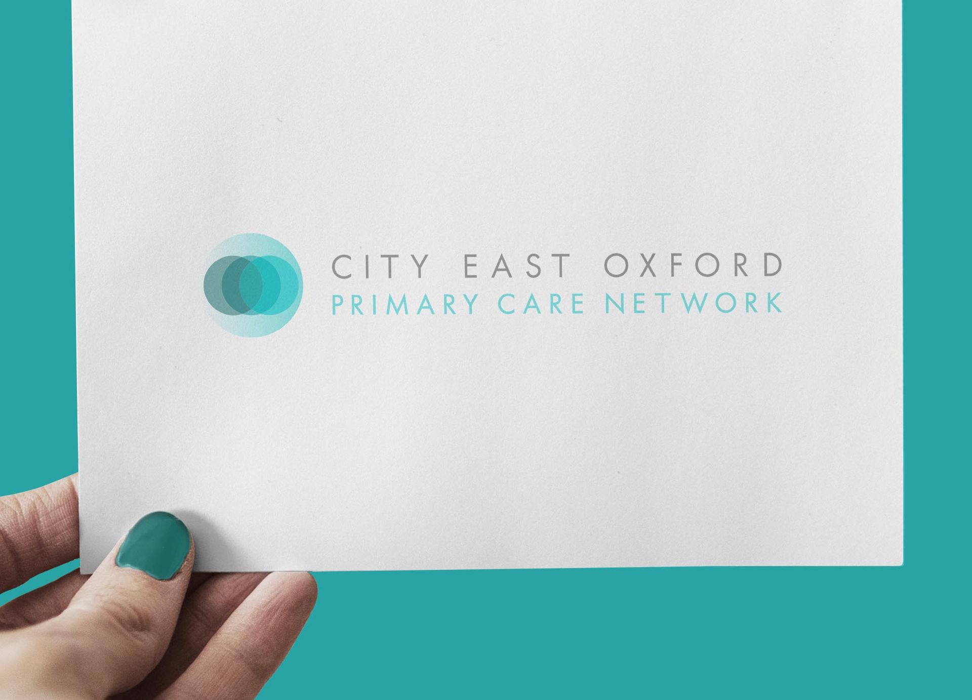 A person is holding a piece of paper that says city east oxford primary care network.
