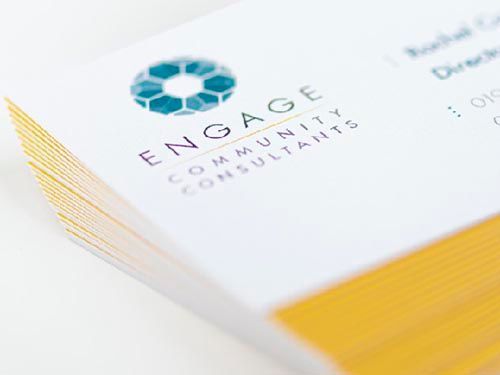 a close up of a stack of business cards for engage community consultants .