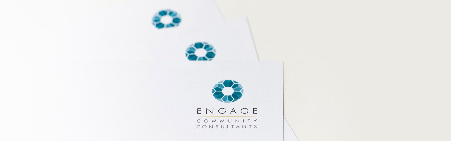 a stack of business cards for engage community consultants