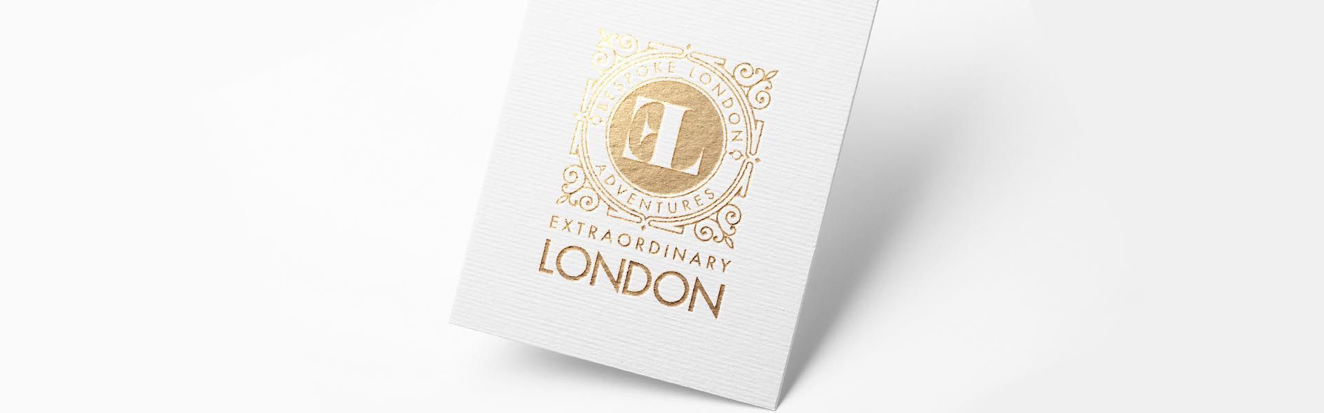 A white card with a gold logo on it is sitting on a white surface.