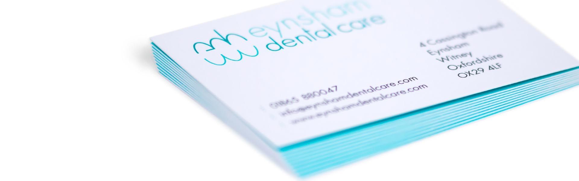 a stack of business cards for eynsham dental care