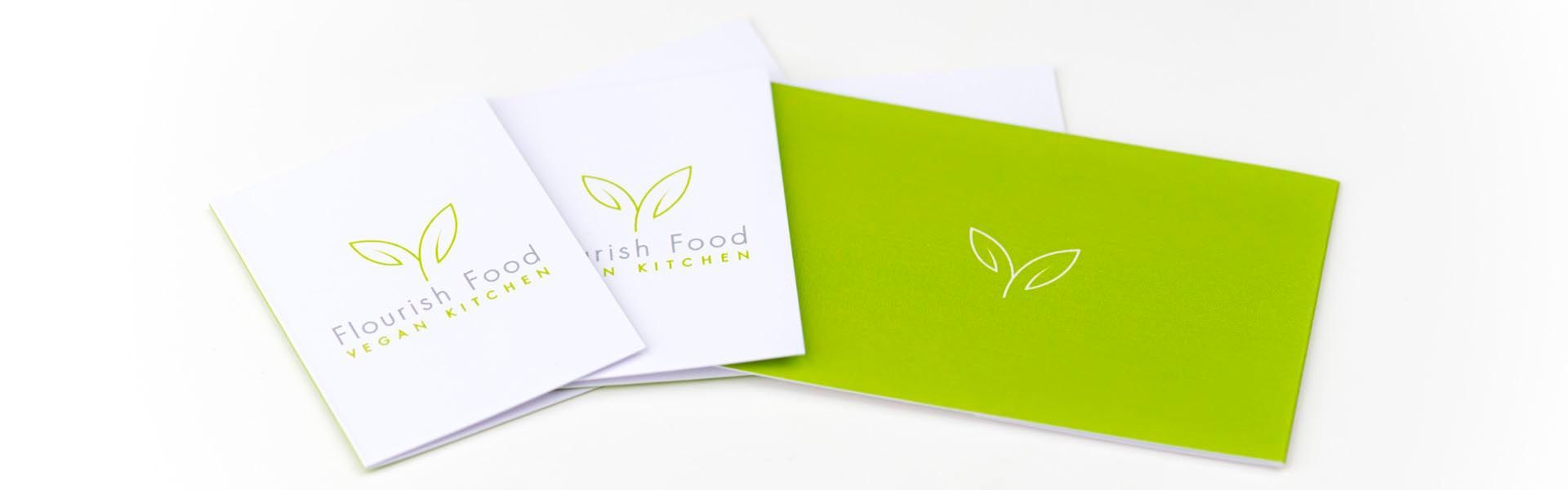 three brochures for flourish food vegan kitchen