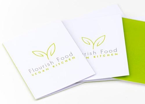 a couple of folders with a logo on them are sitting on top of each other on a table .