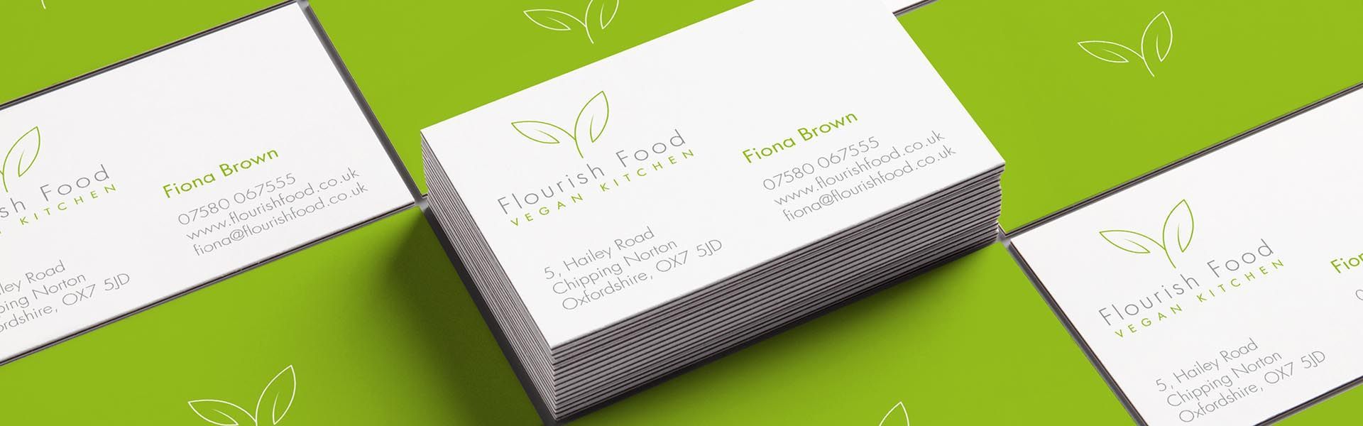 a stack of business cards for flourish food vegan kitchen