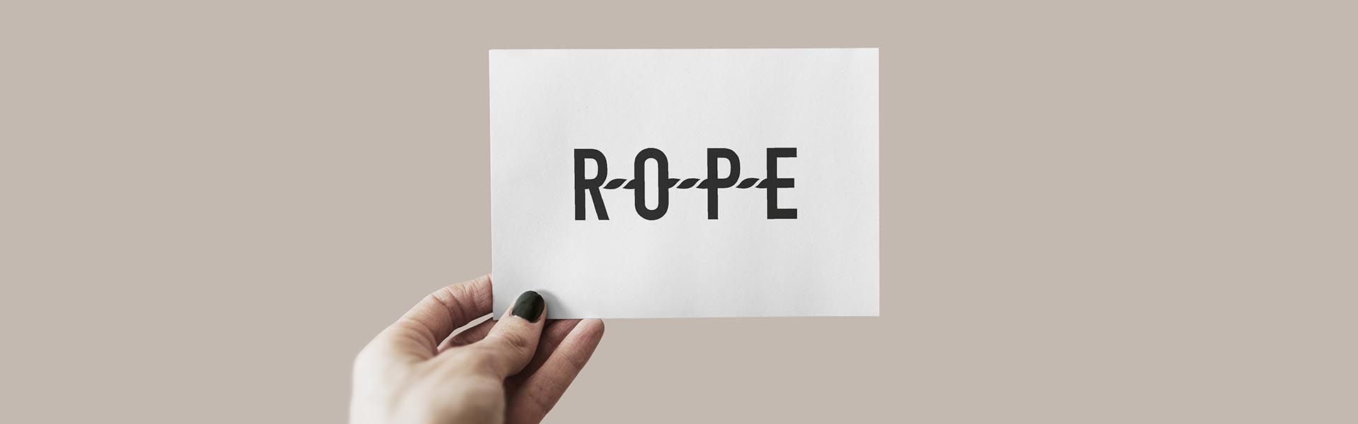 a person holding a piece of paper with the rope system logo on it
