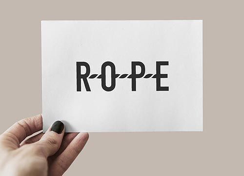 a person is holding a piece of paper with the rope system logo on it .