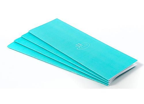 A stack of turquoise colored notebooks with the number 25 on the front