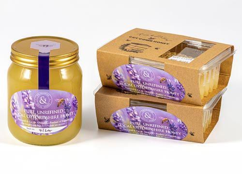 A jar of honey next to two boxes of cut comb honey