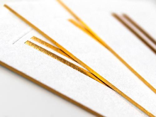 a close up of a business card with gold foil on the edges.