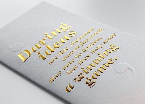 a white piece of paper with gold foil embossed lettering that says