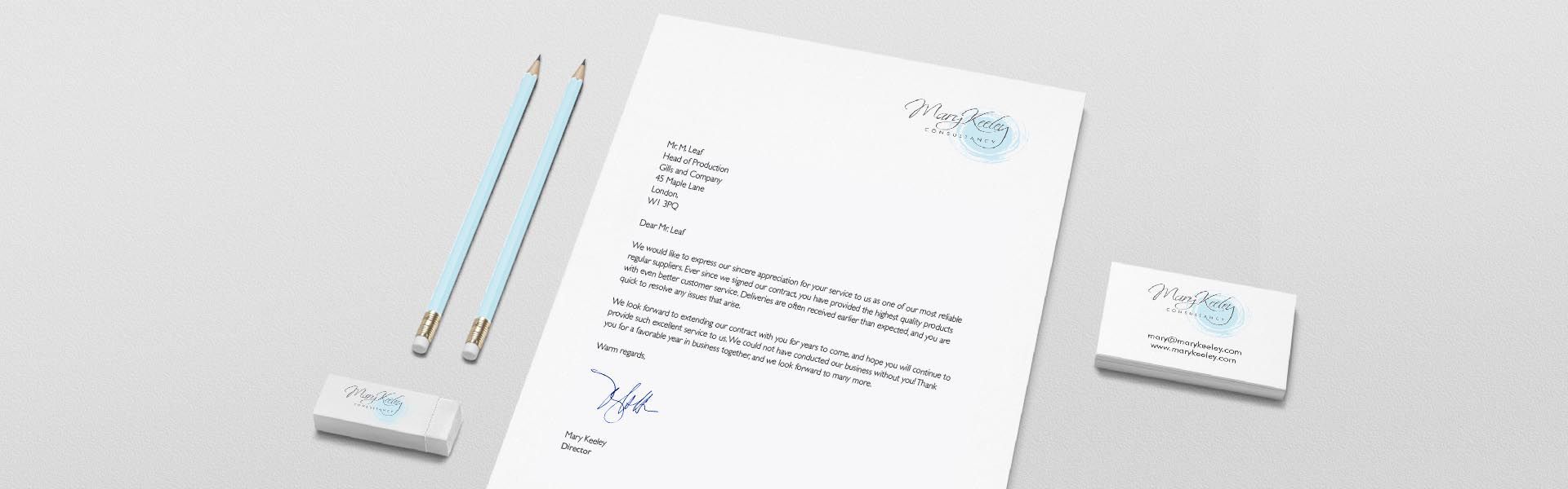 a letter from mary keeley sits next to a pencil and a business card