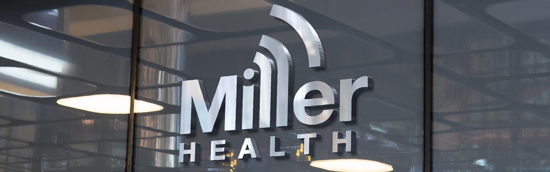 a miller health sign on a glass wall