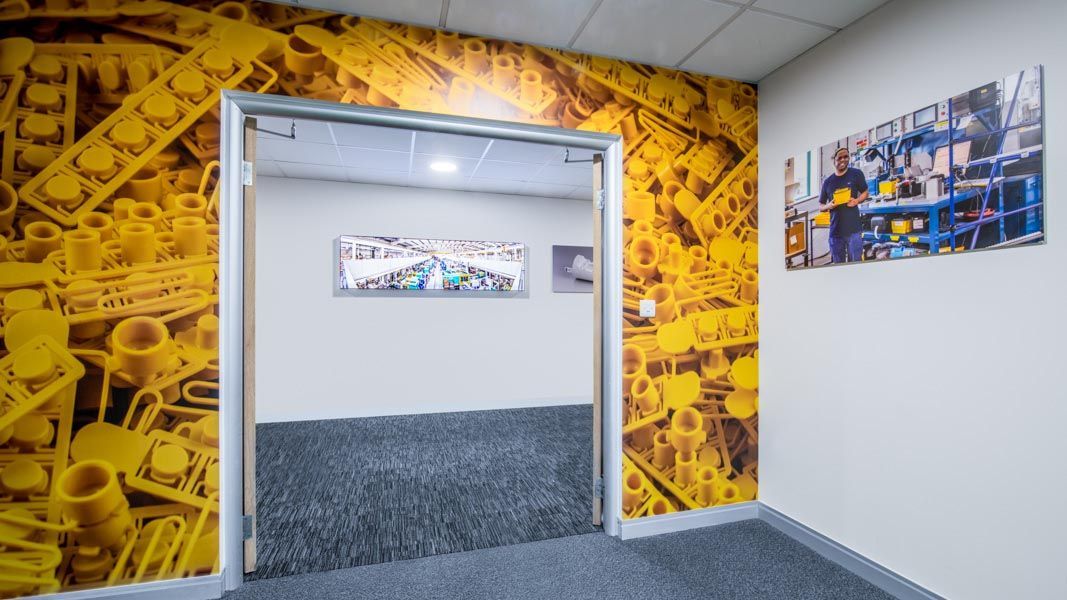 a hallway with a picture of a man in a factory on the wall with large format printed photographic wallpaper