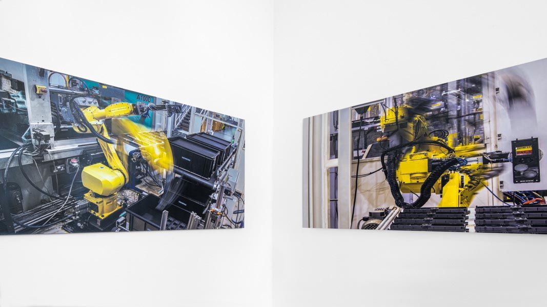two pictures of a moving robotic arm on a wall