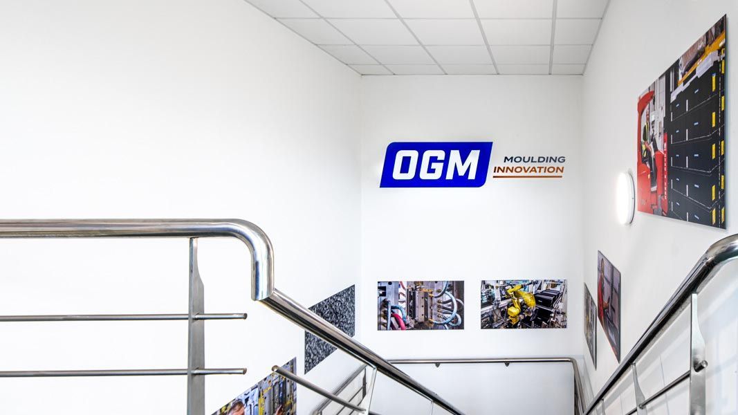 a sign on a wall that says ogm moulding innovation