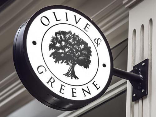 a sign for olive & greene with a tree in the center