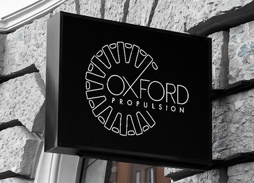 a sign for oxford propulsion hangs on a stone wall