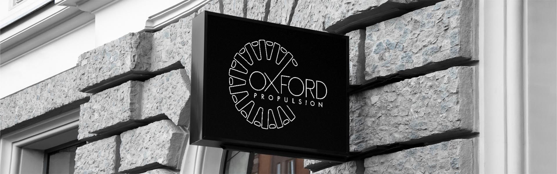 a sign for oxford propulsion hangs on a stone wall